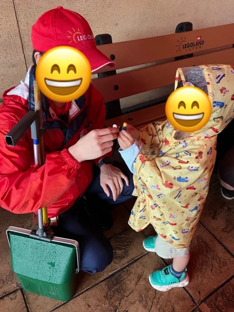 スタッフの方が子どもの目線に合わせてミニフィグ交換を案内している様子